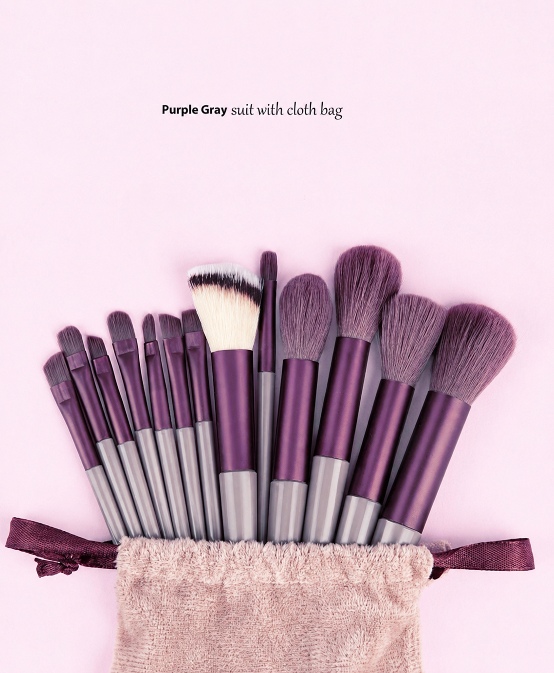 Set of makeup brushes with a cloth bag on a pink background