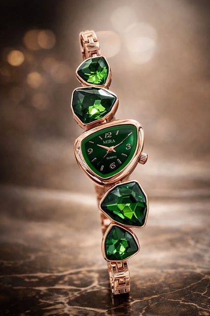 Green gemstone-encrusted watch with rose gold band on a blurred background