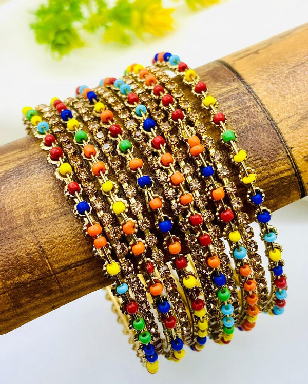 Multicolored beaded bracelets on a wooden stick with a white background