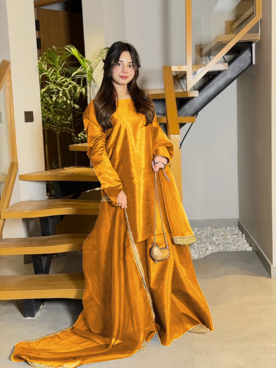 Woman in a mustard yellow traditional outfit standing indoors.