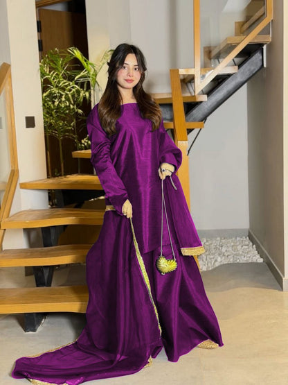 Woman in a long purple dress standing in a home interior.