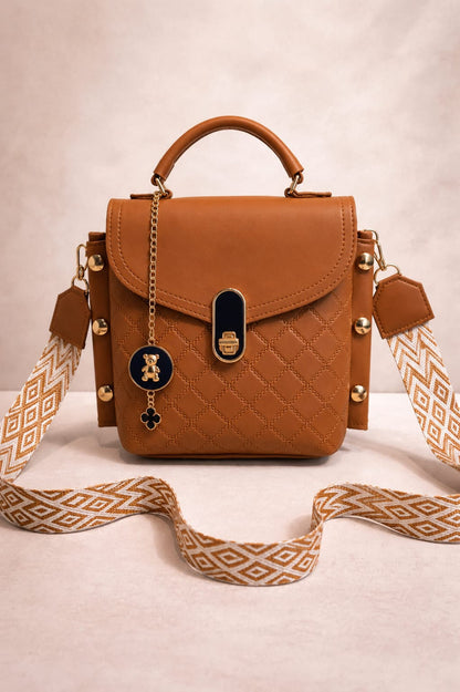 Brown quilted handbag with decorative strap on a beige background