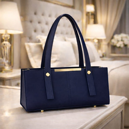 Navy blue handbag with gold accents on a table in a luxurious room.