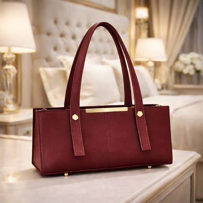 Maroon handbag on a table with a blurred background