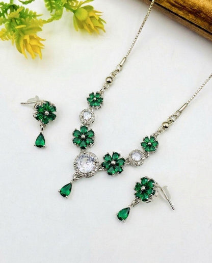 Jewelry set with green gemstones on a white background