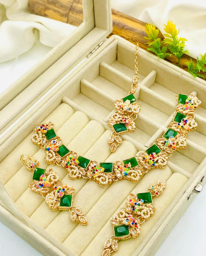 Gold necklace with green gemstones in a jewelry box