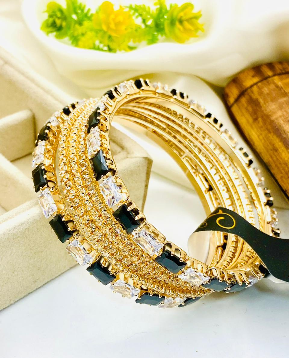 Gold and black bracelet with clear stones on a white surface