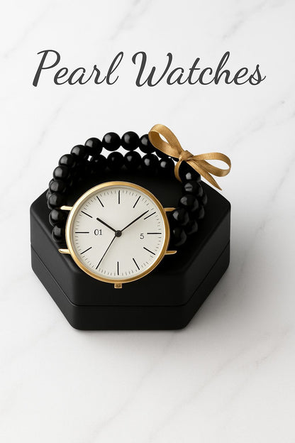 Black watch with gold accents on a black stand, accompanied by a black beaded bracelet with a gold bow, on a white background.