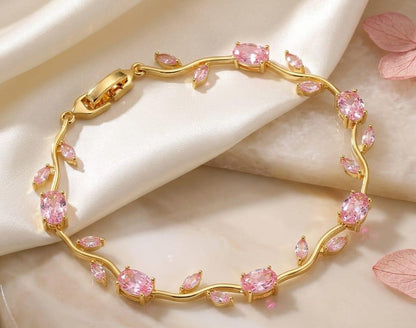 Gold bracelet with pink gemstones on a beige fabric background