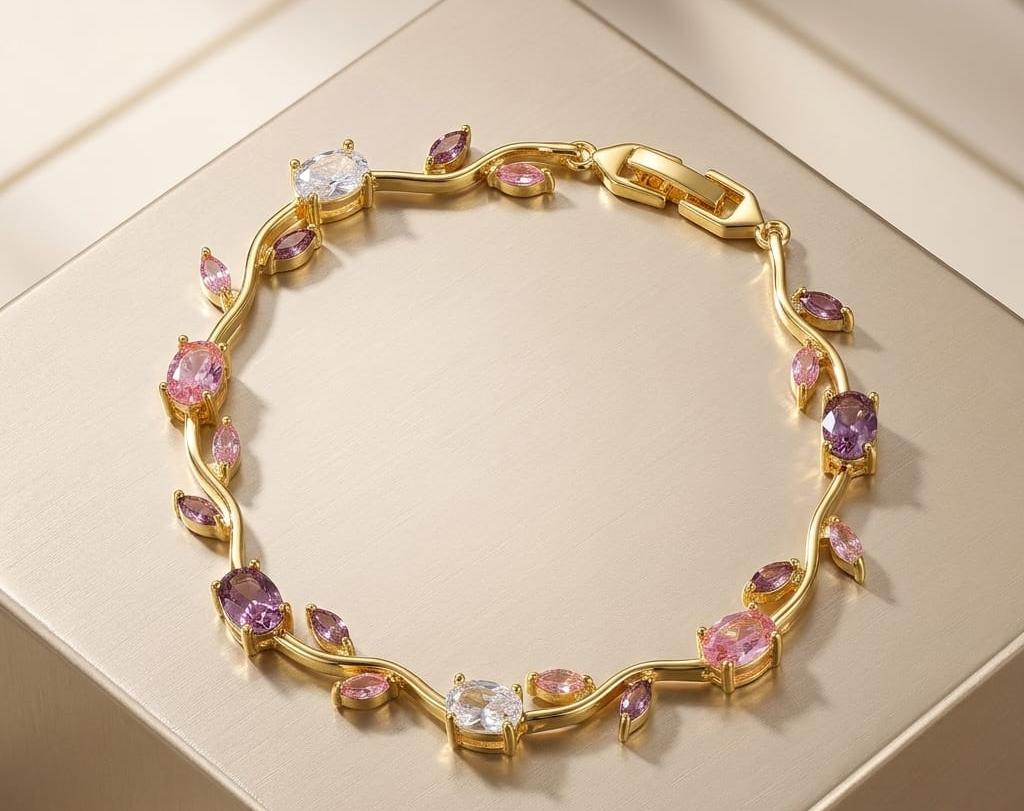 Gold bracelet with pink and purple gemstones on a beige background