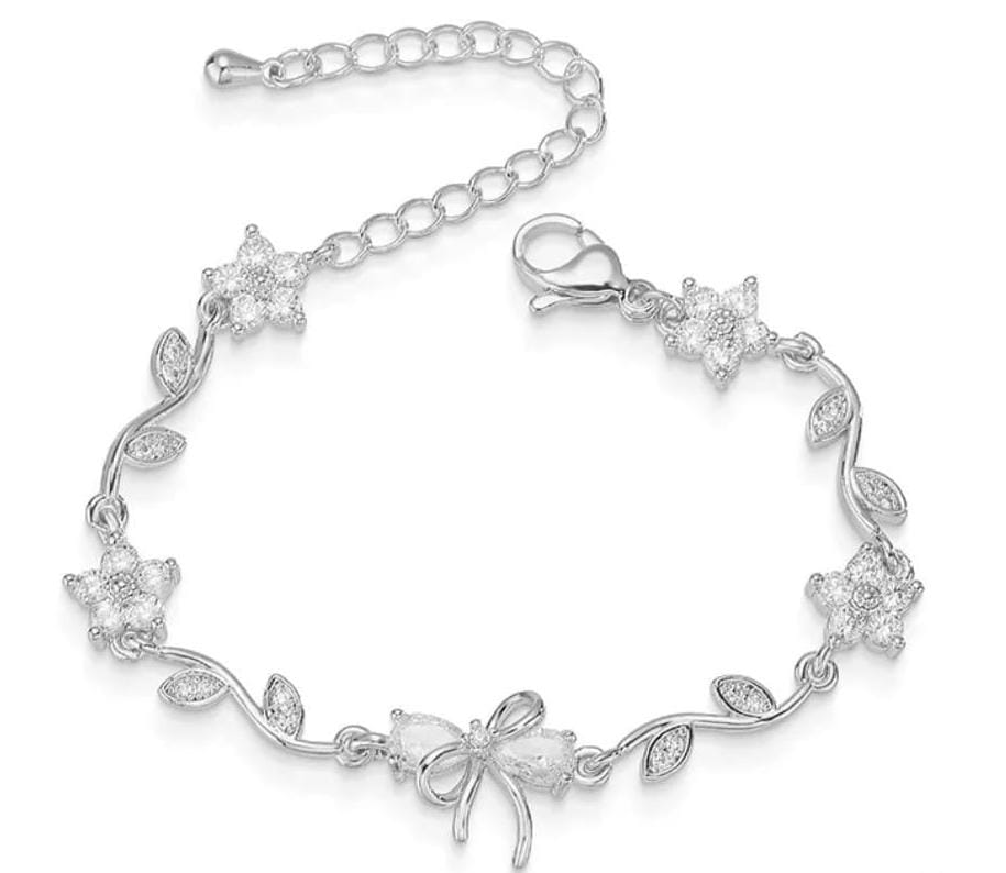 A silver-toned bracelet featuring a vine design with leaf-shaped links, five star-shaped floral clusters, and a central bow motif, all embellished with clear stones. The bracelet is displayed on a clean white background.
