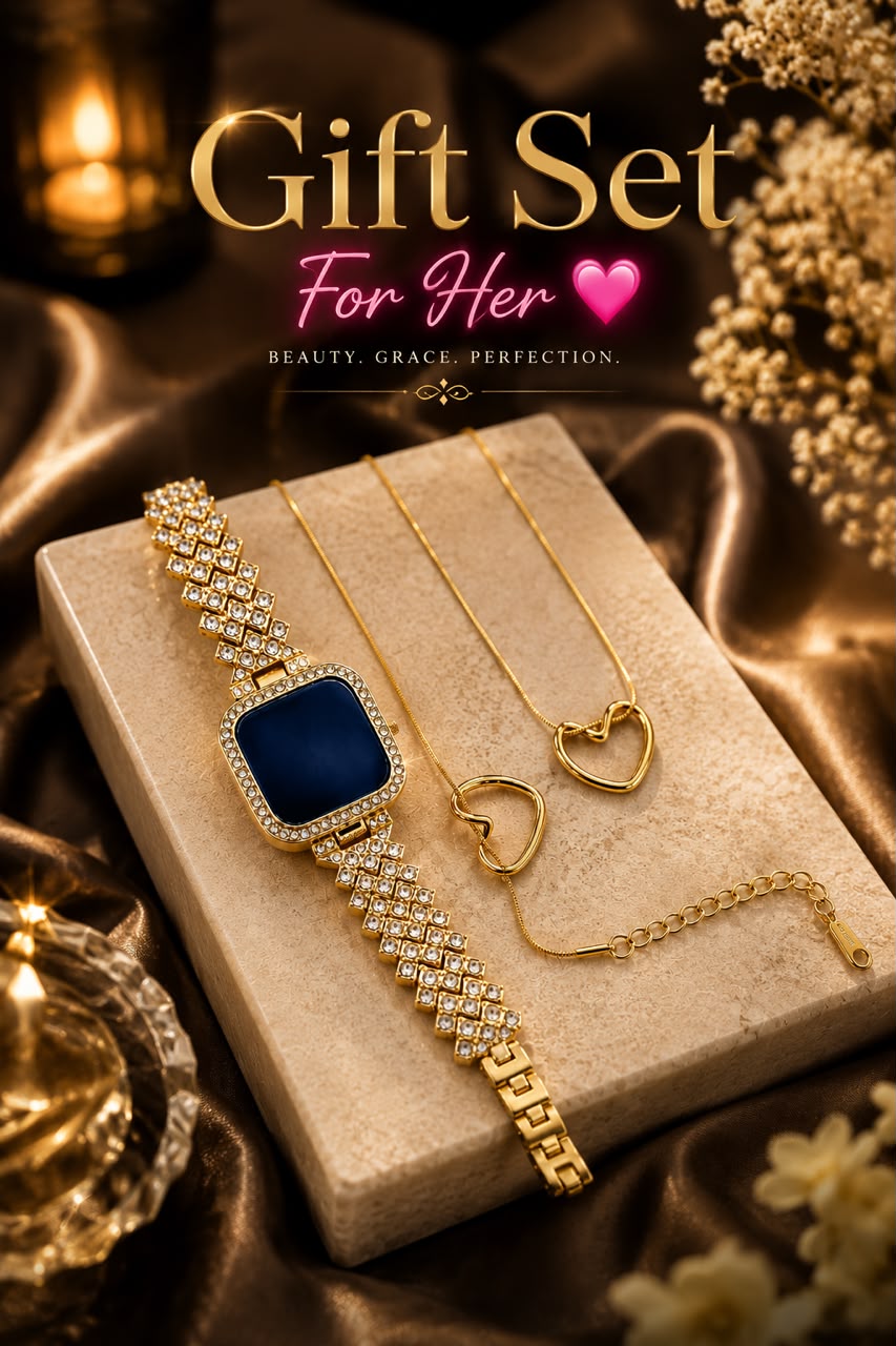 Gold jewelry gift set for her, featuring a watch with a deep blue square face and crystal-encrusted bracelet, a matching gold heart pendant necklace, and a heart-shaped ring, displayed on a beige stone block with decorative gold fabric and flowers.