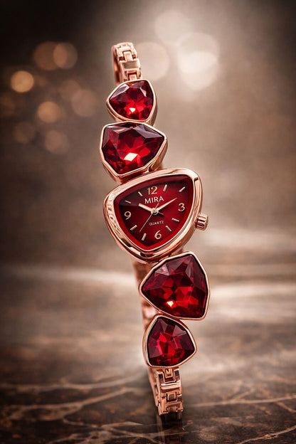 Rose gold watch with red gemstones on a reflective surface